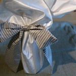 Bottle Wraps - sq of fabric with sash tied in a bow.